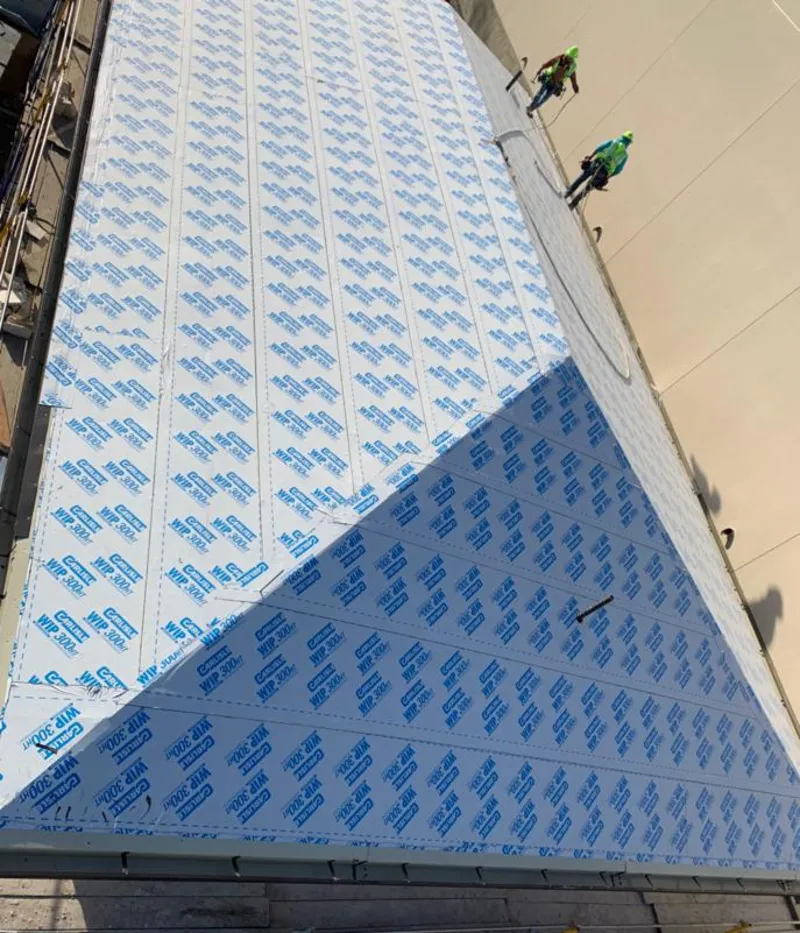 Professional roofers installing underlayment on a metal roof in Martinsville